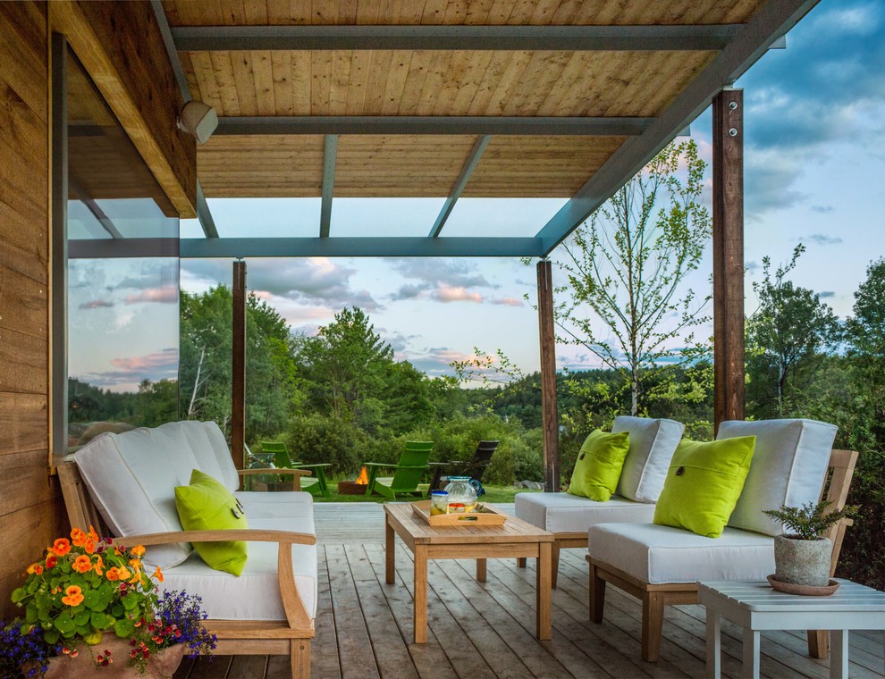 Cette photo montre une terrasse arrière moderne avec un foyer extérieur et une extension de toiture.