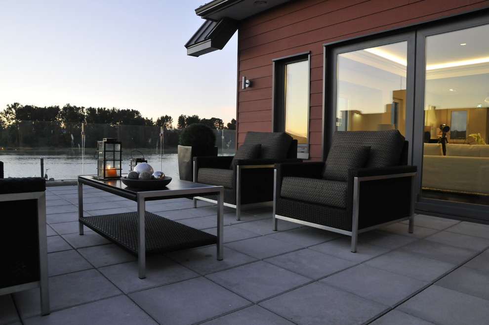 На фото: двор среднего размера на боковом дворе в стиле модернизм с покрытием из декоративного бетона без защиты от солнца