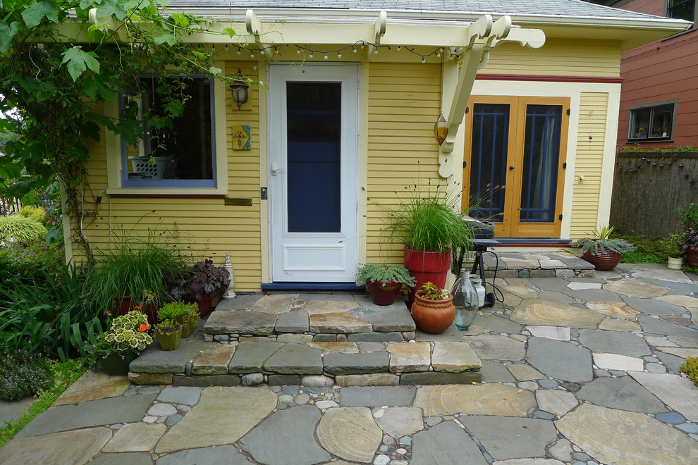 This is an example of a bohemian patio steps in Portland with natural stone paving and no cover.