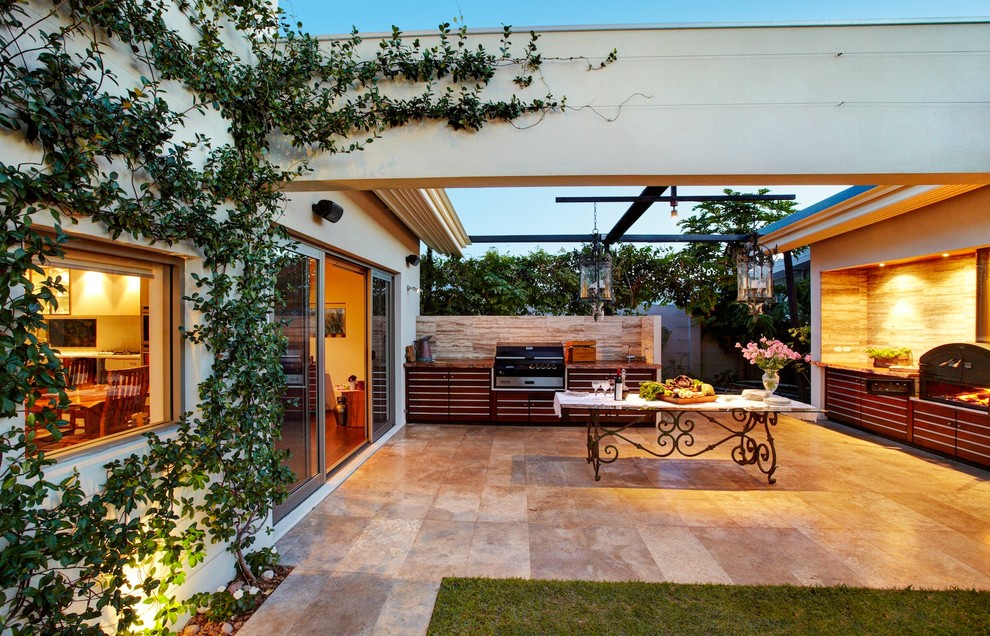 Пример оригинального дизайна: двор на заднем дворе в современном стиле с летней кухней, покрытием из каменной брусчатки и козырьком