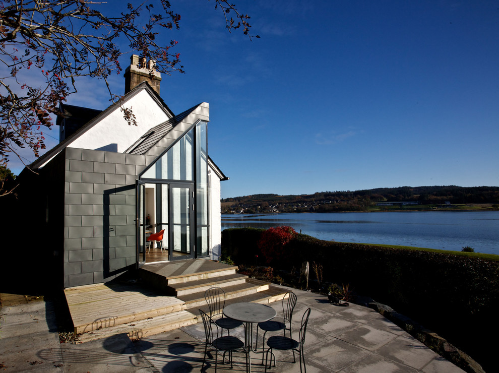 Photo of a coastal side patio in Edinburgh with concrete paving and no cover.