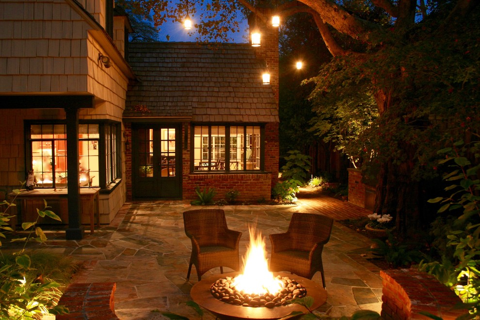 Klassischer Patio hinter dem Haus mit Feuerstelle und Natursteinplatten in Sacramento