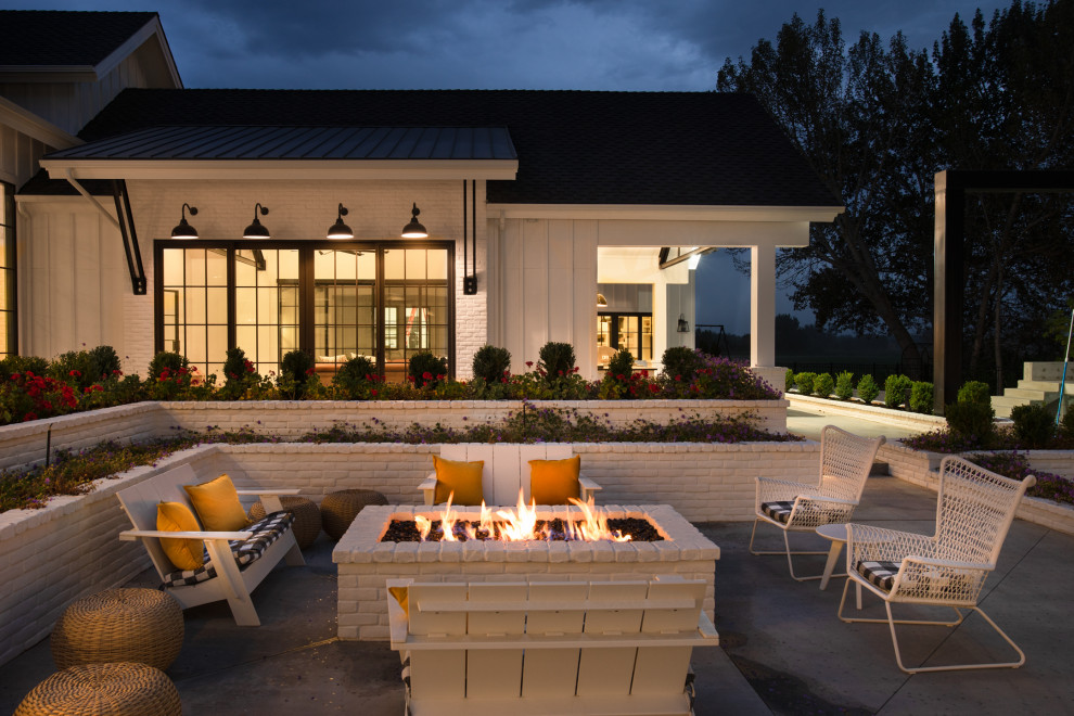 Example of a cottage concrete patio design in Boise with a fire pit and no cover