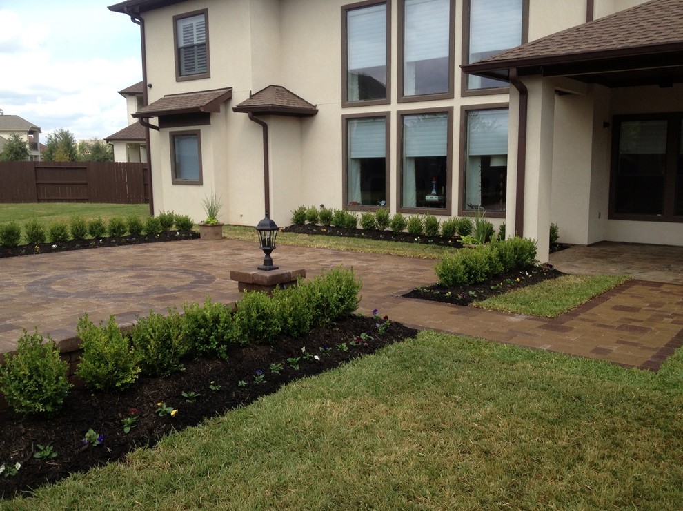 This is an example of a classic back patio in Houston with a water feature and concrete paving.