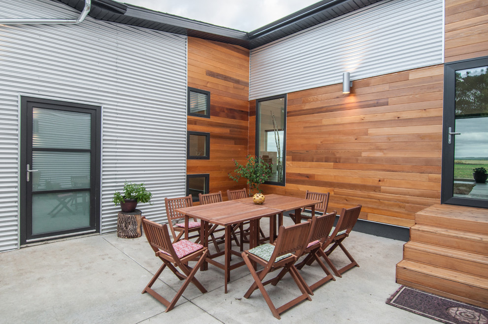 На фото: двор в современном стиле с покрытием из бетонных плит без защиты от солнца