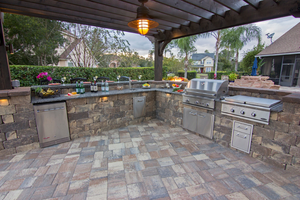 Imagen de patio tradicional grande en patio con cocina exterior, adoquines de piedra natural y pérgola