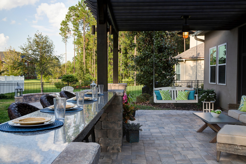 Immagine di un patio o portico chic di medie dimensioni e dietro casa con un focolare, pavimentazioni in pietra naturale e una pergola