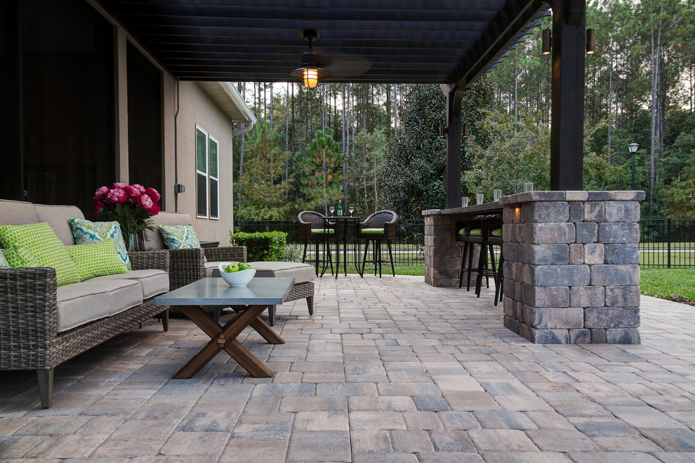 Photo of a medium sized traditional back patio in Jacksonville with a fire feature, natural stone paving and a pergola.