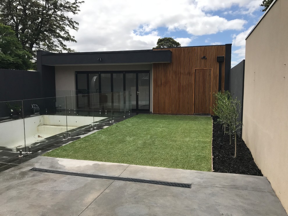 Diseño de patio contemporáneo de tamaño medio sin cubierta en patio trasero con suelo de baldosas