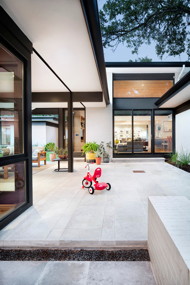 Mittelgroßer, Überdachter Moderner Patio im Innenhof mit Kübelpflanzen und Natursteinplatten in Austin