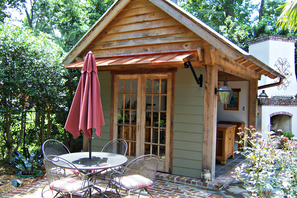 Ispirazione per un patio o portico stile rurale di medie dimensioni e dietro casa con pavimentazioni in mattoni e un parasole