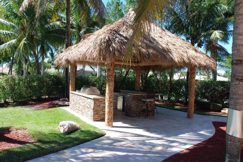 Exemple d'une grande terrasse arrière bord de mer avec une cuisine d'été, des pavés en pierre naturelle et un gazebo ou pavillon.