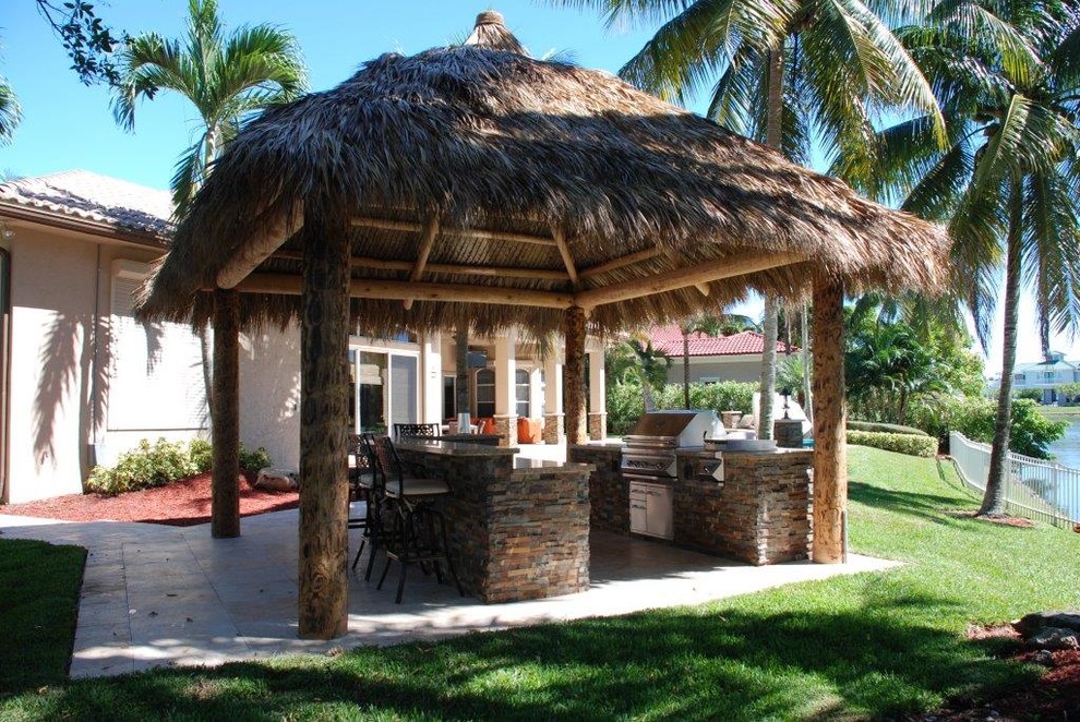 Großer Maritimer Patio hinter dem Haus mit Outdoor-Küche, Natursteinplatten und Gazebo in Miami