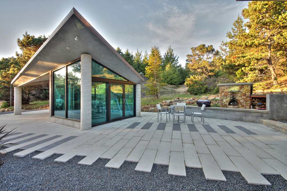 Пример оригинального дизайна: двор среднего размера на переднем дворе в современном стиле с местом для костра и покрытием из каменной брусчатки