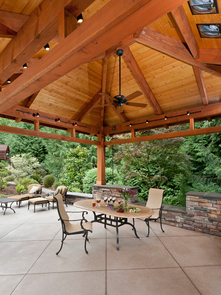 Cette image montre une grande terrasse arrière traditionnelle avec un gazebo ou pavillon, une cuisine d'été et une dalle de béton.