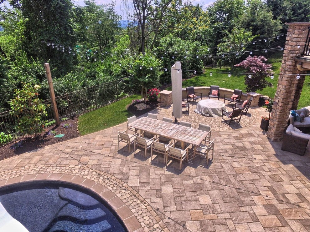 Photo of a large contemporary back patio in Philadelphia with an outdoor kitchen, concrete paving and a roof extension.