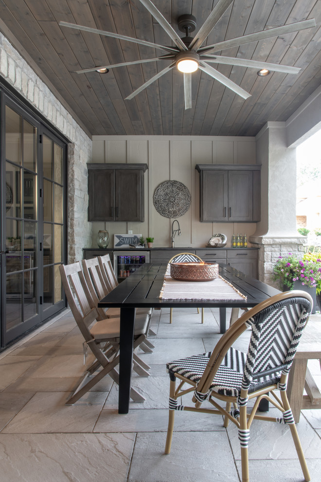 Cette photo montre une terrasse arrière chic de taille moyenne avec une extension de toiture et du béton estampé.