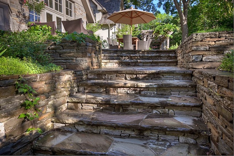 Modelo de patio clásico en patio trasero con adoquines de piedra natural y pérgola