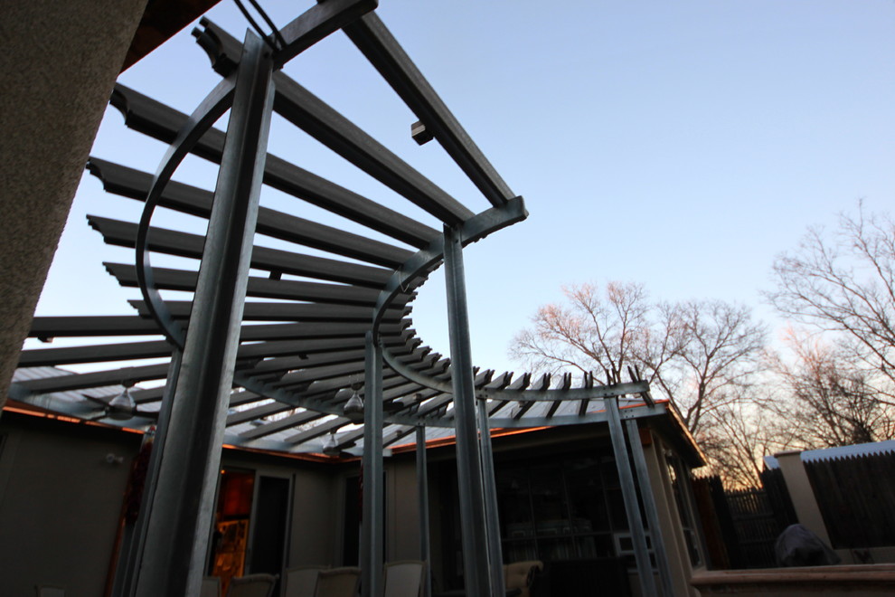 Idee per un grande patio o portico industriale dietro casa con pavimentazioni in mattoni e una pergola