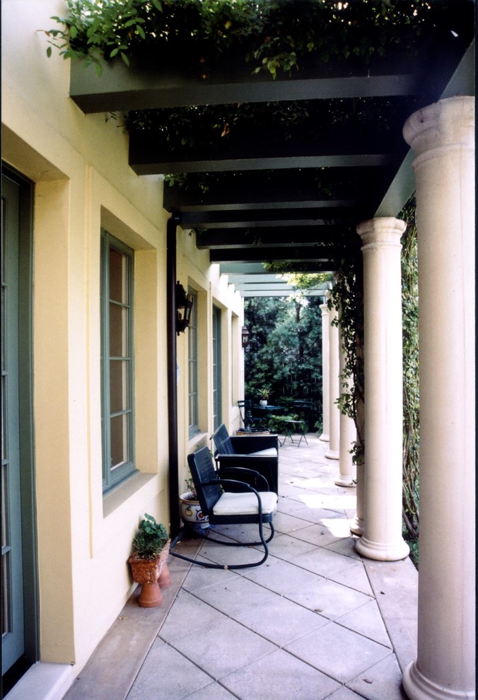 Esempio di un grande patio o portico chic dietro casa con lastre di cemento e un parasole