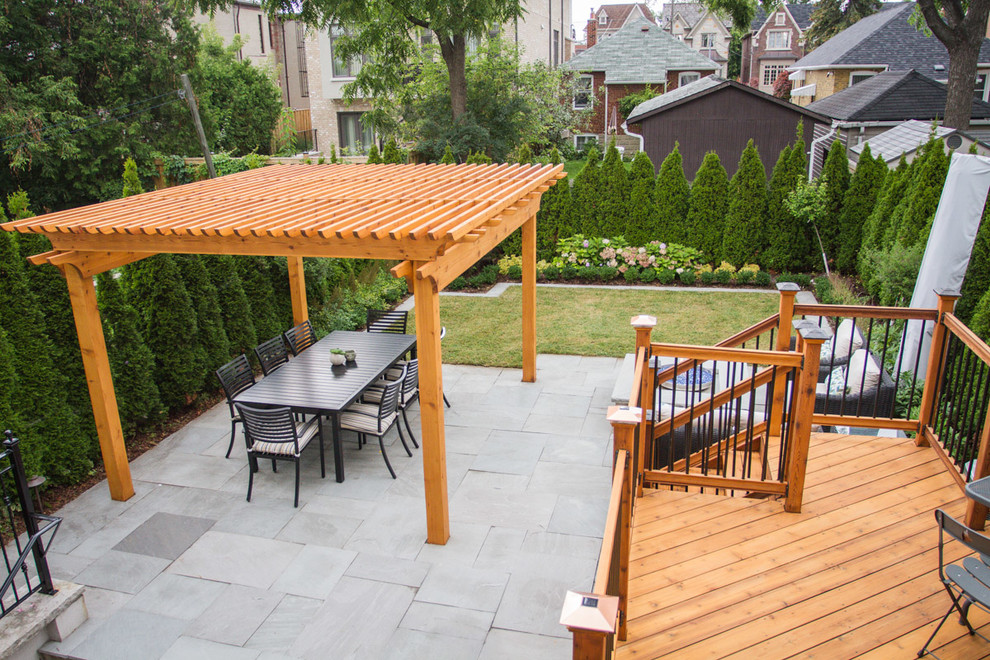 Immagine di un piccolo patio o portico design dietro casa con pavimentazioni in pietra naturale e una pergola