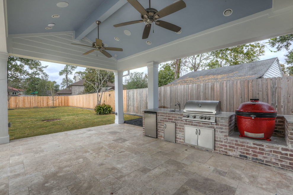 Cette photo montre une grande terrasse arrière chic avec une cuisine d'été, du carrelage et une extension de toiture.