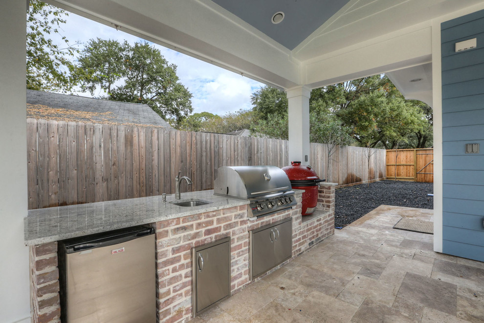 Cette photo montre une grande terrasse arrière chic avec une cuisine d'été, du carrelage et une extension de toiture.