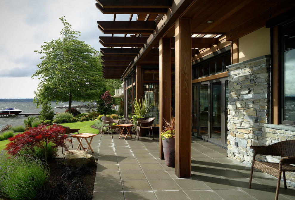 Inspiration for a large transitional backyard concrete paver patio remodel in Seattle with a roof extension