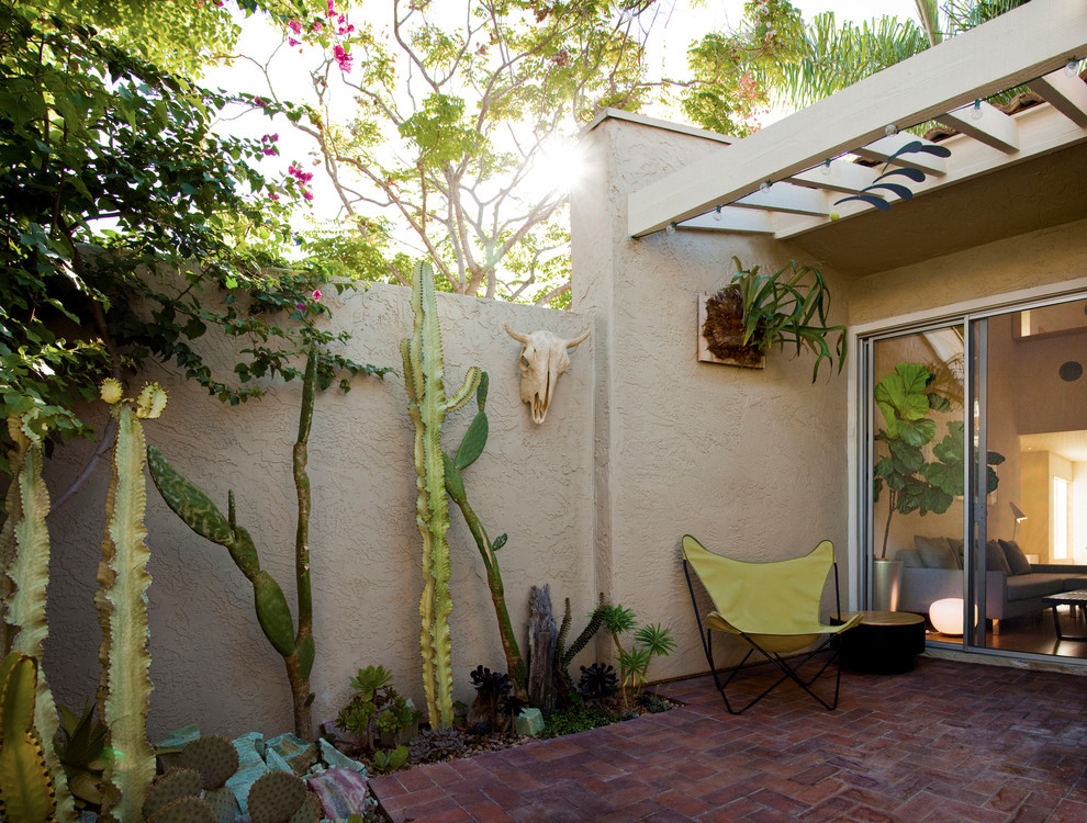 На фото: двор в стиле фьюжн с мощением клинкерной брусчаткой без защиты от солнца