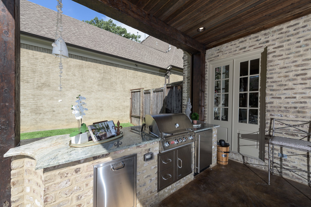 Esempio di un ampio patio o portico dietro casa con un tetto a sbalzo e cemento stampato