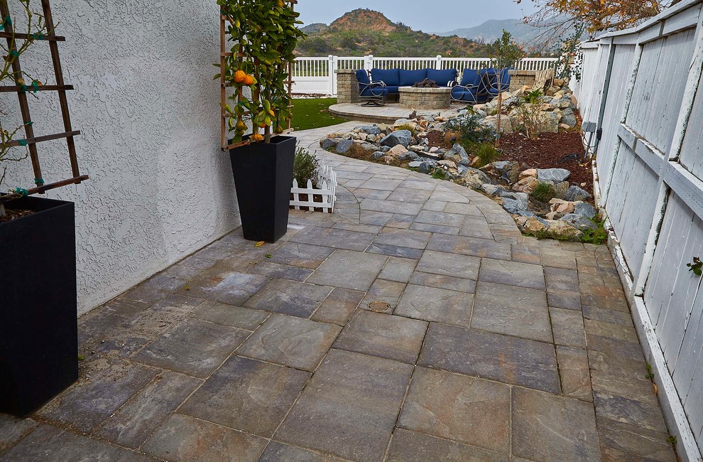 This is an example of a small traditional back patio in Orange County with a fire feature and concrete paving.