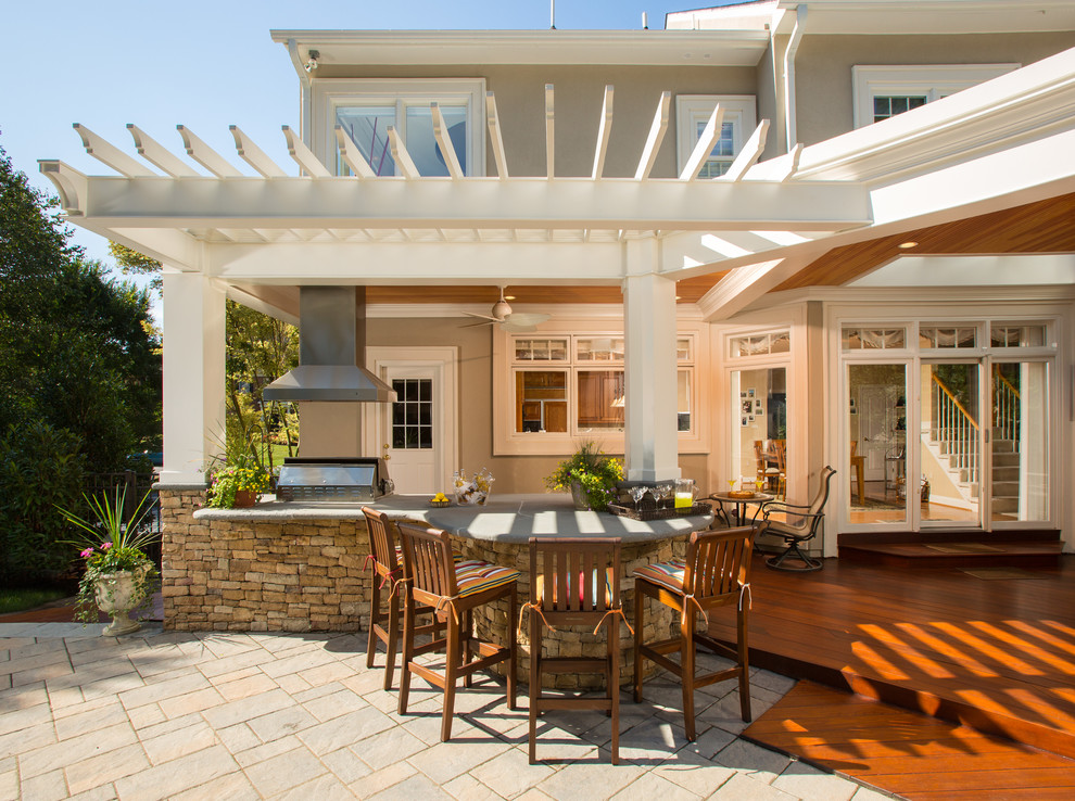 Foto di un ampio patio o portico tropicale dietro casa con pavimentazioni in cemento e un tetto a sbalzo