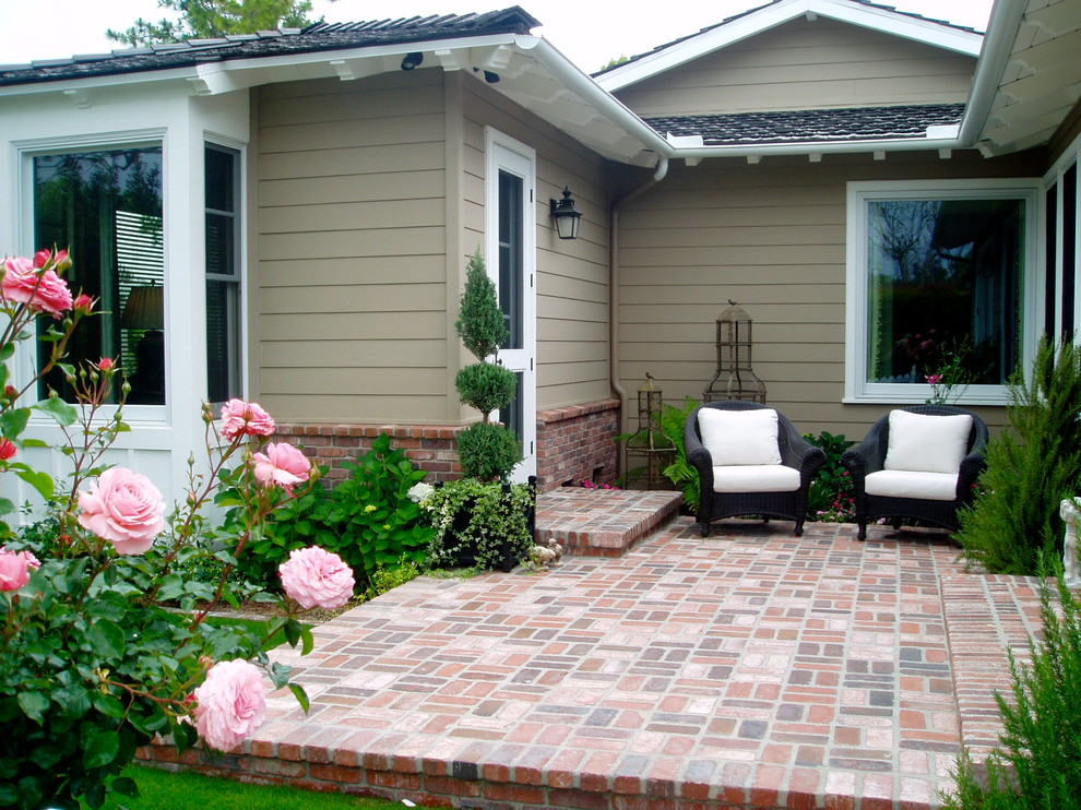Esempio di un patio o portico classico davanti casa con pavimentazioni in mattoni