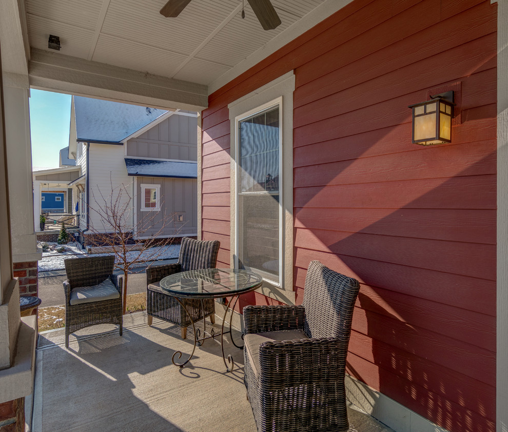 Foto di un piccolo patio o portico american style dietro casa con un caminetto, pavimentazioni in cemento e un tetto a sbalzo