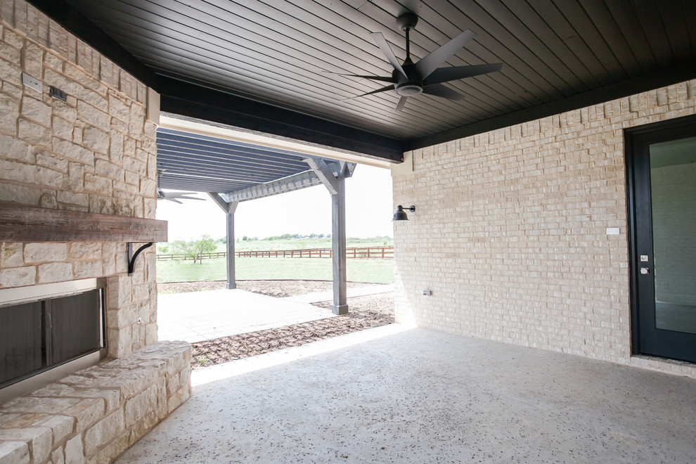 На фото: большой двор на заднем дворе в стиле модернизм с местом для костра, покрытием из бетонных плит и навесом с