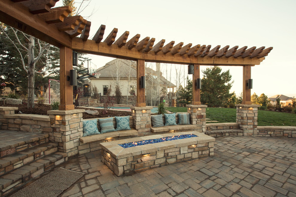 This is an example of a traditional patio in Denver with a fire feature and natural stone paving.