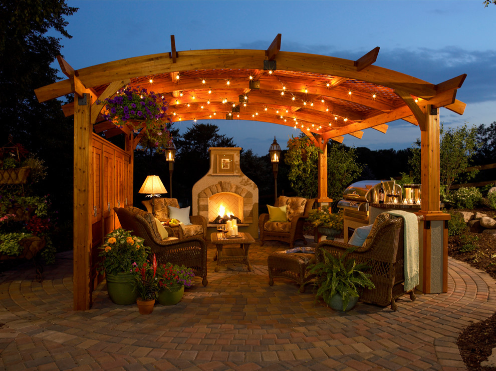 Patio - large traditional backyard stone patio idea in Other with a gazebo