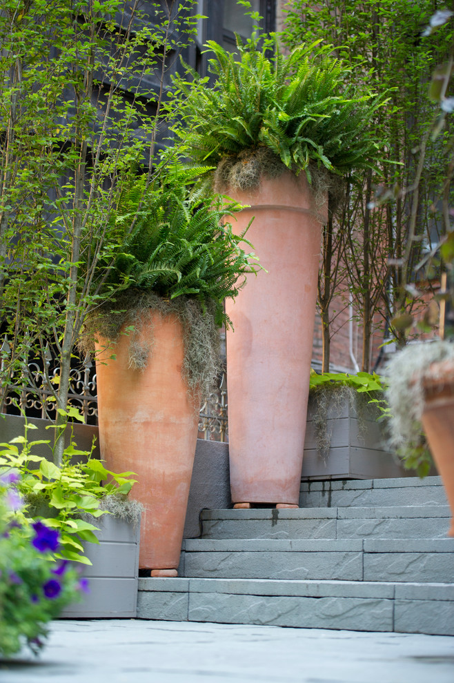 Imagen de patio tradicional pequeño sin cubierta en patio con jardín de macetas y adoquines de piedra natural