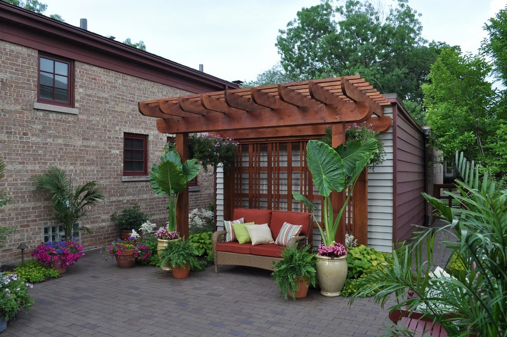 Immagine di un patio o portico chic con pavimentazioni in mattoni