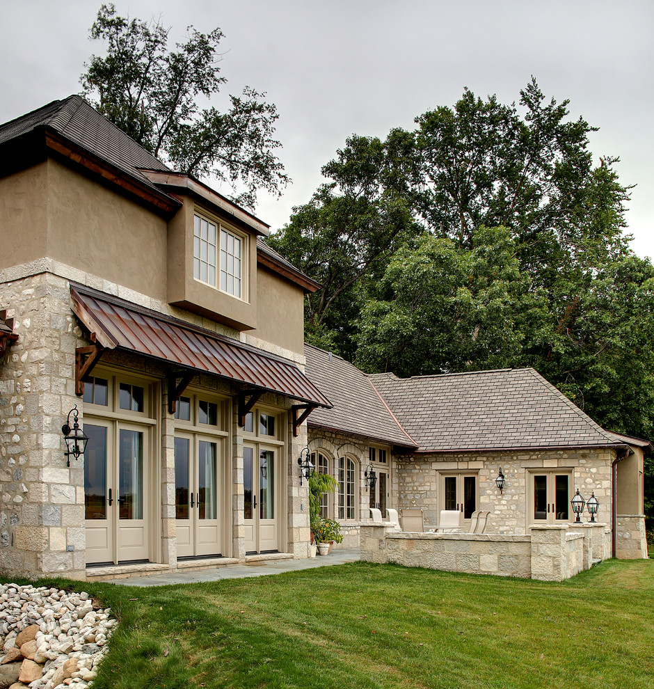 Immagine di un ampio patio o portico chic dietro casa con pavimentazioni in pietra naturale e un parasole