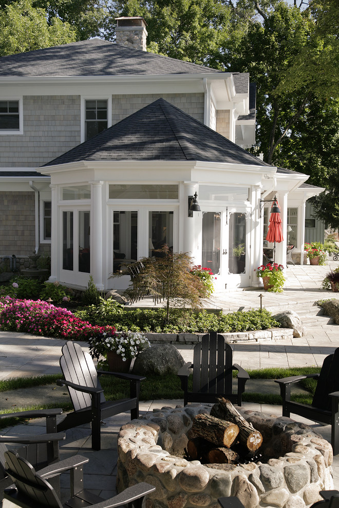 Huge elegant front yard stamped concrete patio photo in Other with a fire pit and a roof extension