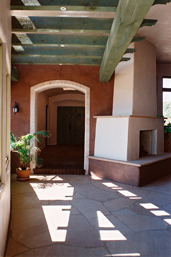 Foto di un patio o portico american style di medie dimensioni e dietro casa con un focolare, pavimentazioni in pietra naturale e una pergola