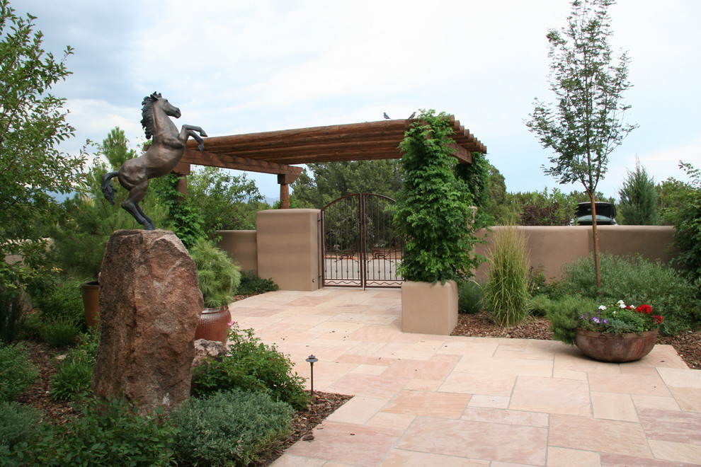 Aménagement d'une terrasse avec des plantes en pots avant sud-ouest américain avec des pavés en pierre naturelle et une pergola.