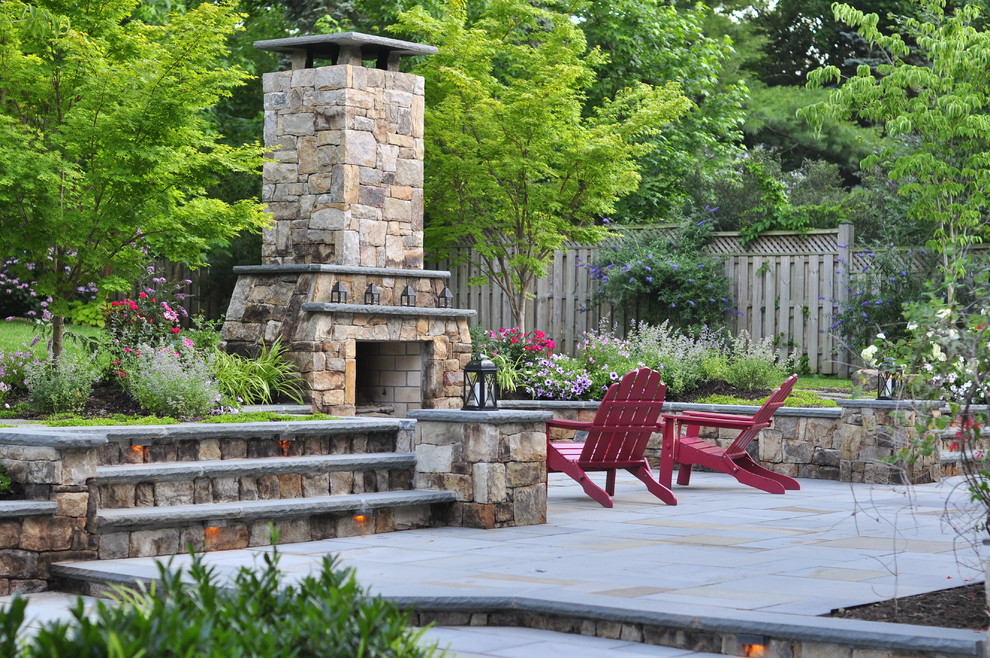 Large elegant backyard stone patio photo in DC Metro with a fire pit and no cover