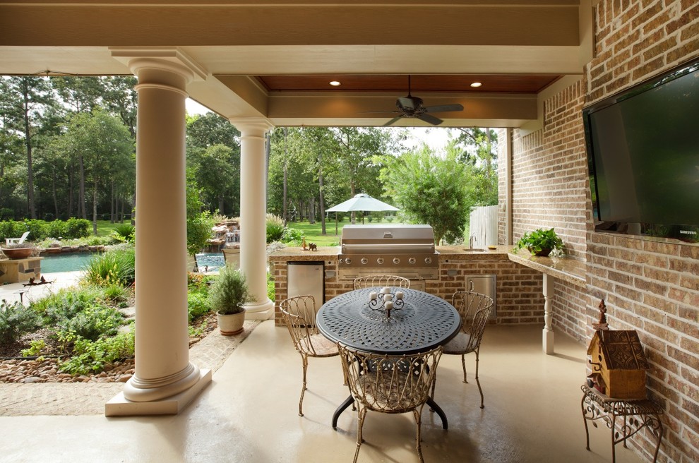 Idee per un grande patio o portico tradizionale dietro casa con lastre di cemento e un tetto a sbalzo