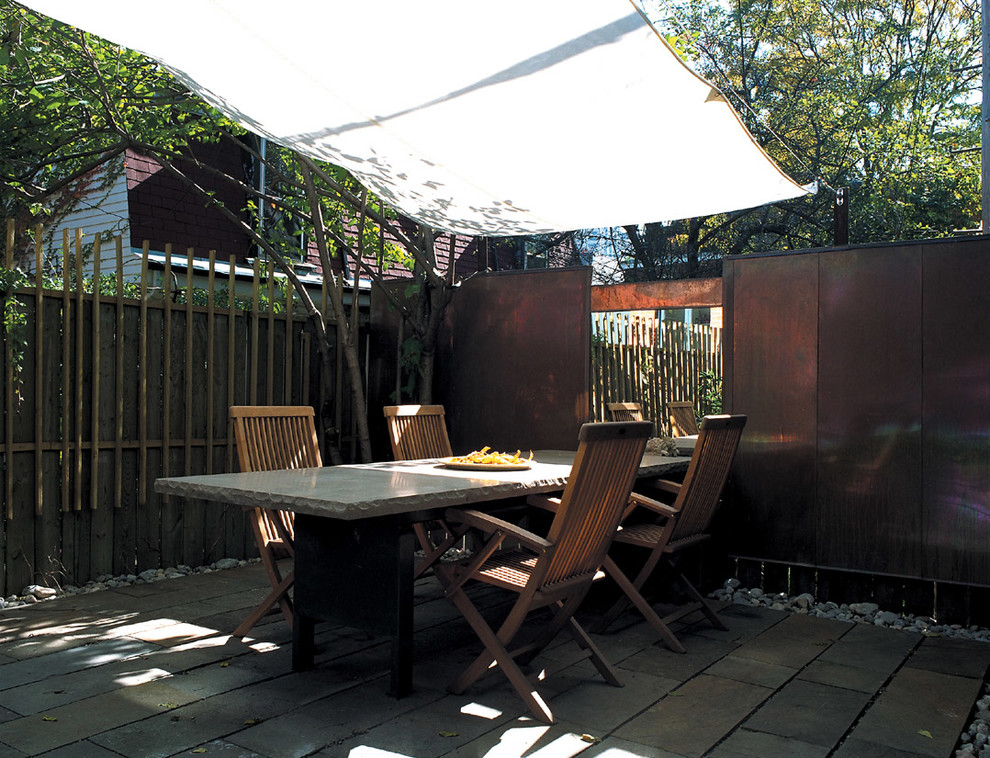 Photo of a medium sized contemporary back patio in Toronto with natural stone paving.