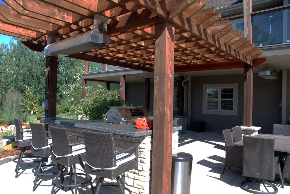 Diseño de patio clásico renovado extra grande en patio trasero con cocina exterior, adoquines de piedra natural y pérgola