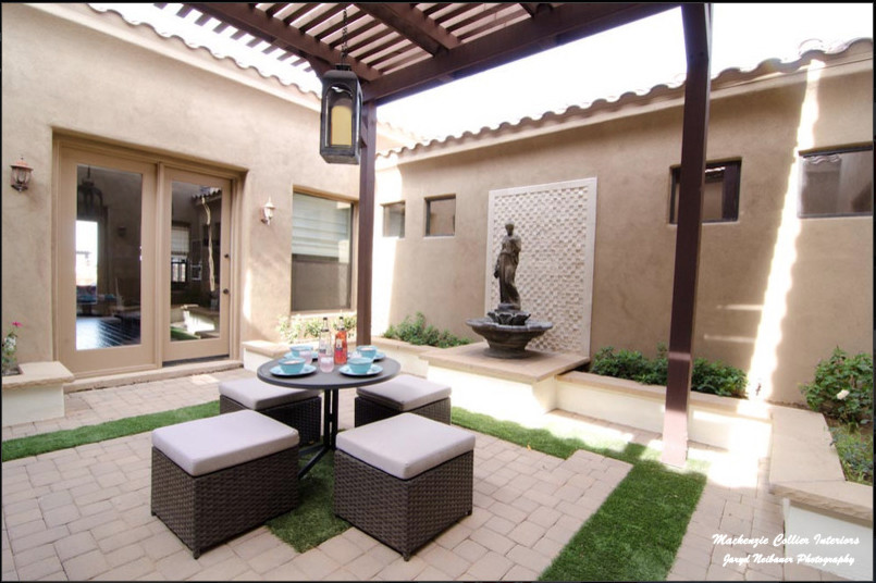 Cette photo montre une grande terrasse chic avec une cour, des pavés en béton et une pergola.