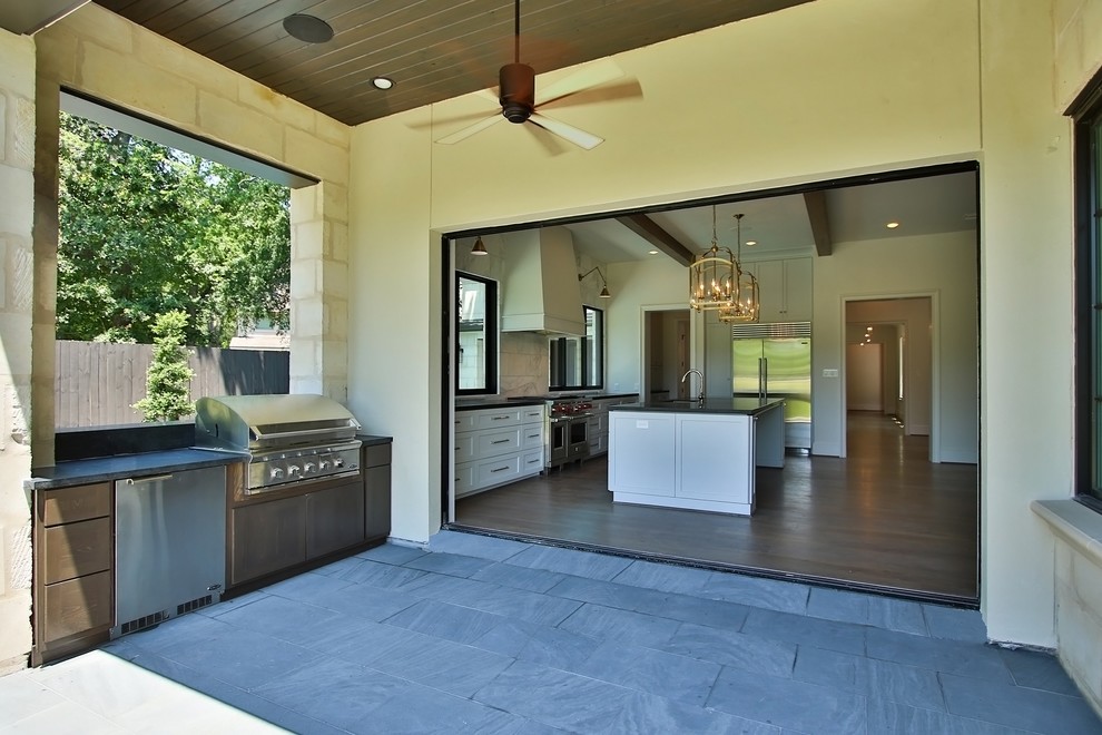 Mittelgroßer, Überdachter Klassischer Patio neben dem Haus mit Outdoor-Küche und Natursteinplatten in Houston