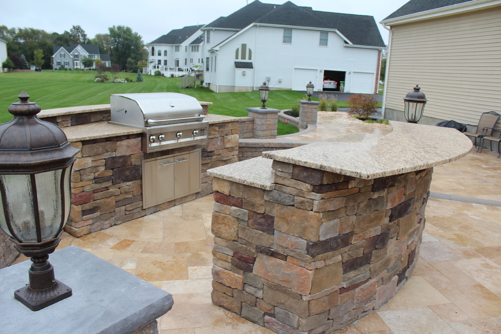 Idée de décoration pour une terrasse arrière tradition de taille moyenne avec une cuisine d'été et des pavés en pierre naturelle.